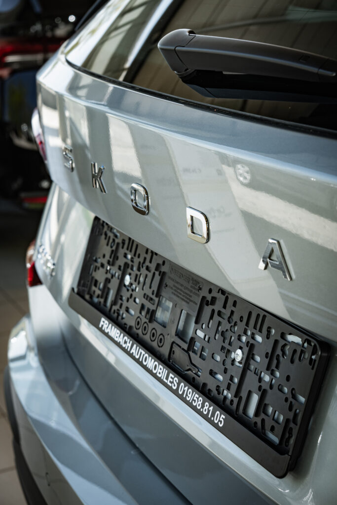 Photo qui met en avant les lettres SKODA à l'arrière d'une voiture grise sans plaque