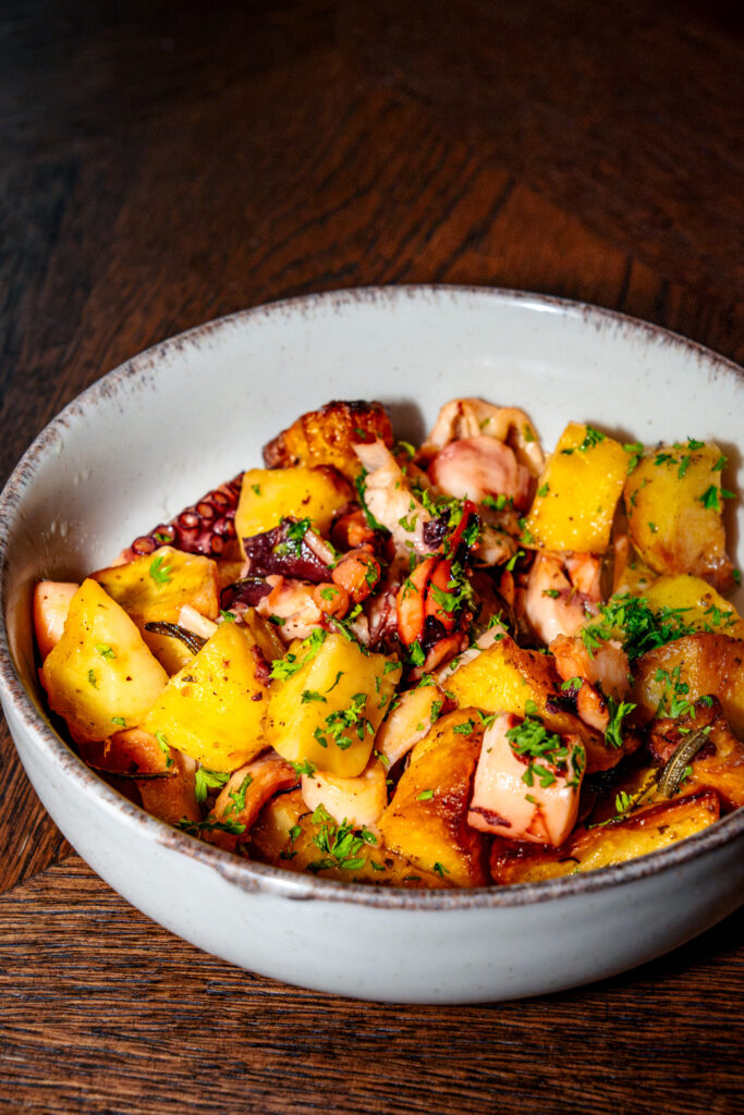 Une salade de poulpe et pommes de terres servie à table dans un bol