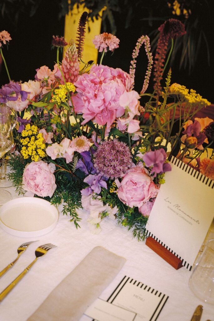 une table dressée aec des fleurs, une fiche nom de table, un menu et une nominette