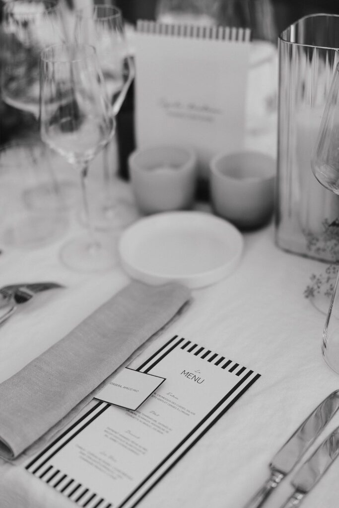 Une photo en noir et blanc du menu posé sur la table avec une nominette par dessus